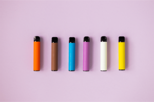 colourful disposable vapes on a lilac background